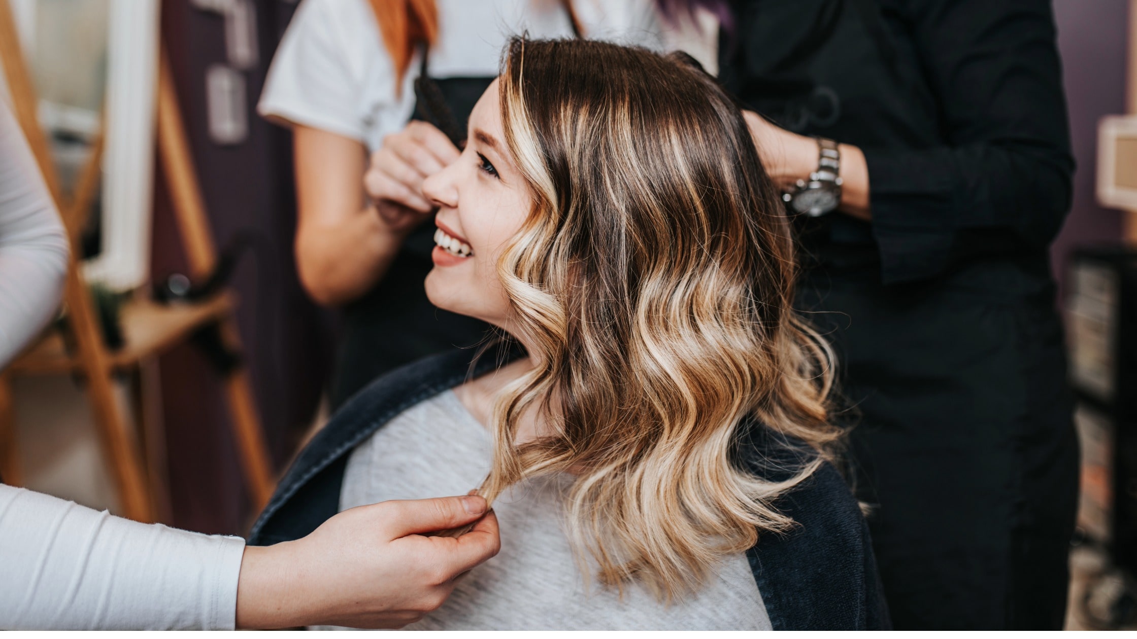 Donna con capelli biondi e babylight naturale durante trattamento in salone parrucchiere a Milano