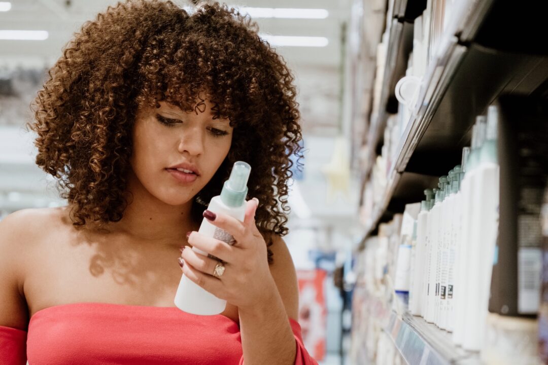 Donna al super market che sceglie lo shampoo giusto